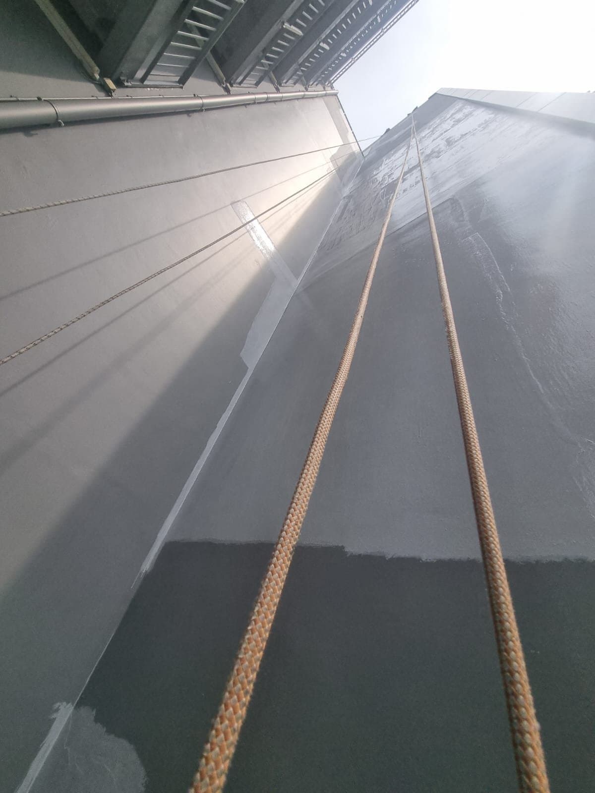 Upward view of a multi-storey commercial building façade in Singapore’s Tai Seng area with Hydroseal twin access ropes running the full height