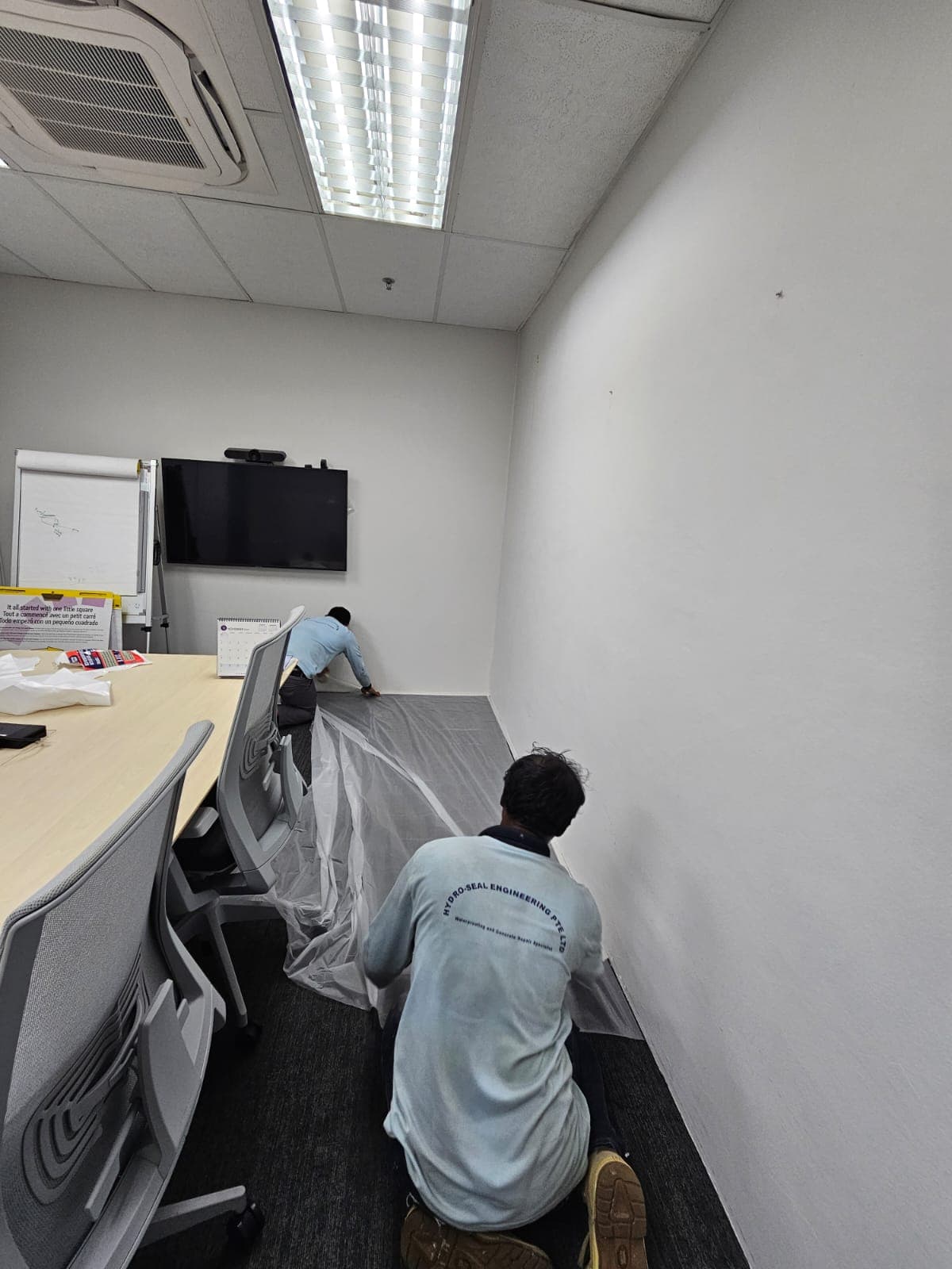 Hydroseal specialist applying waterproofing to a commercial office wall in Singapore
