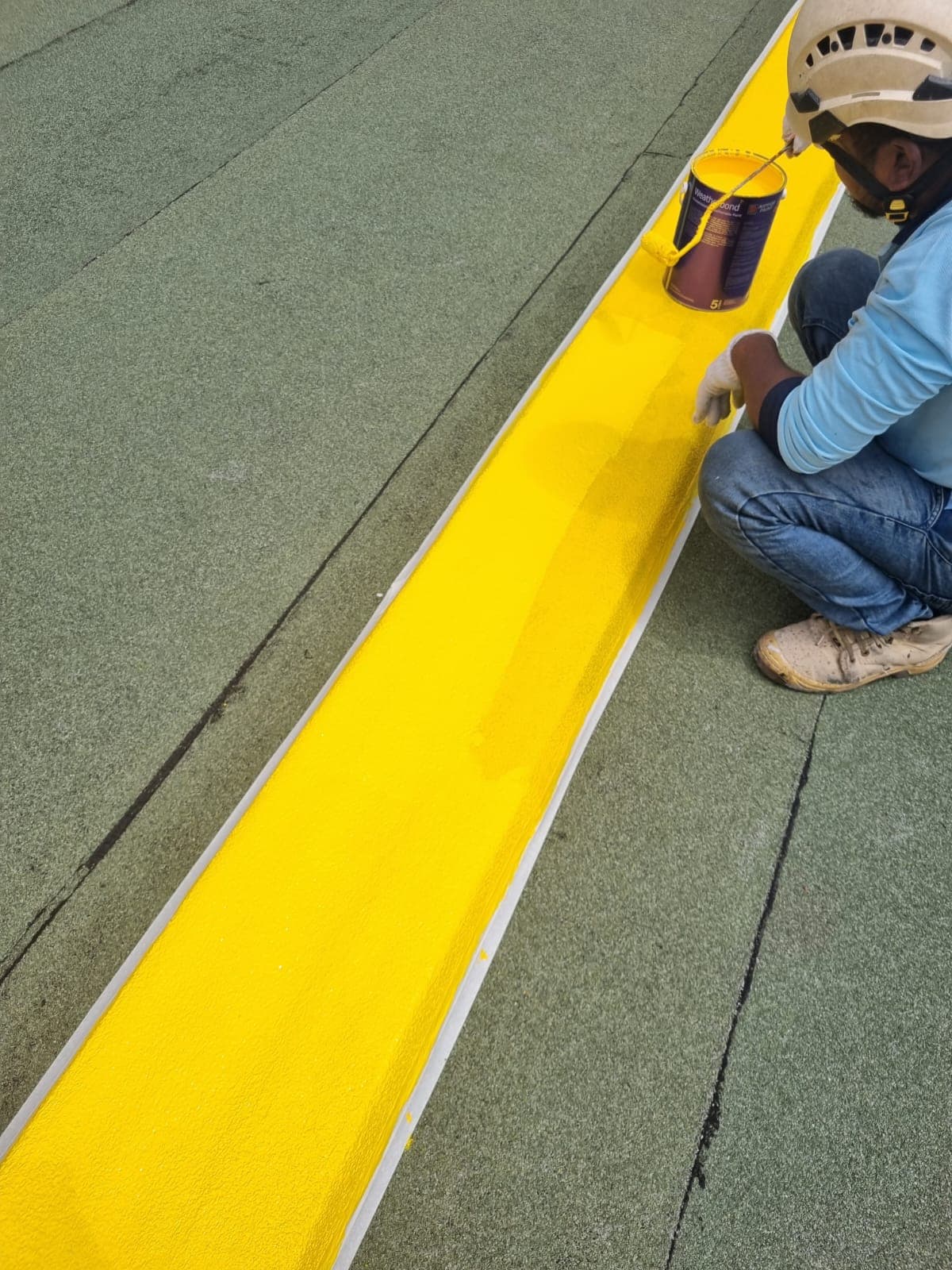 Close-up of a waterproofing membrane coating being applied on a roof in Singapore