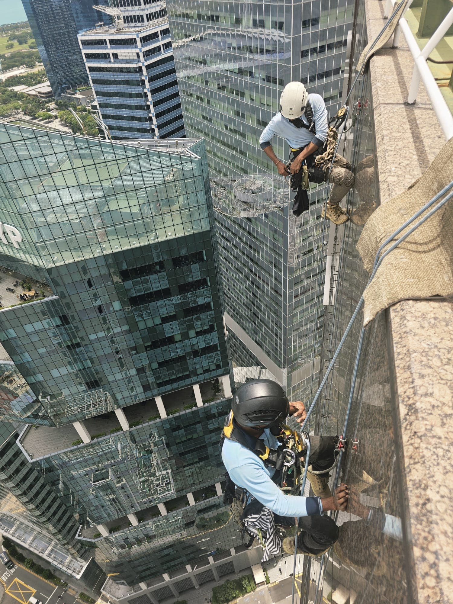 Two Hydroseal IRATA technicians abseiling a high-rise façade in the Singapore Central Business District